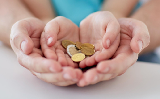 Child and adult hands with coins: MetalsWired Kids Korner Blog